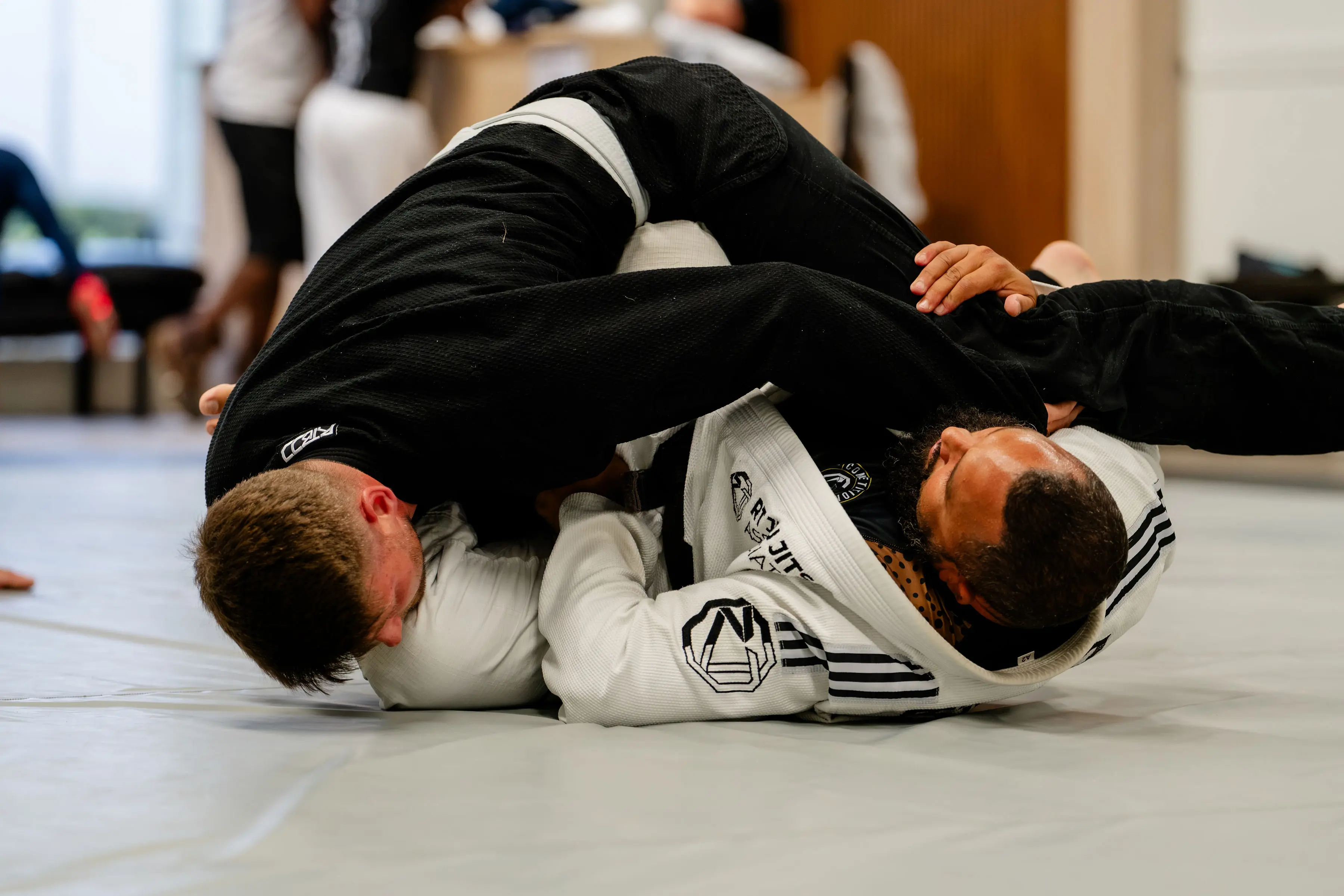 Adults Jiu Jitsu class at RT Beachside: two training partners working a pin on the mats