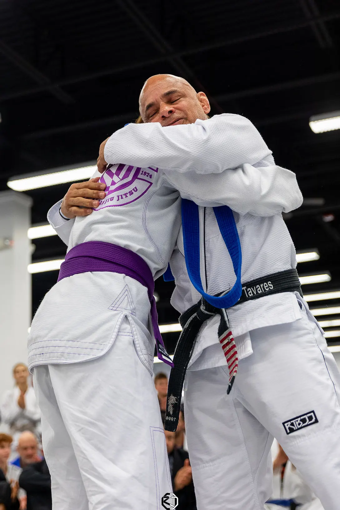 Master Renato Tavares hugging the student right after tying her purple belt