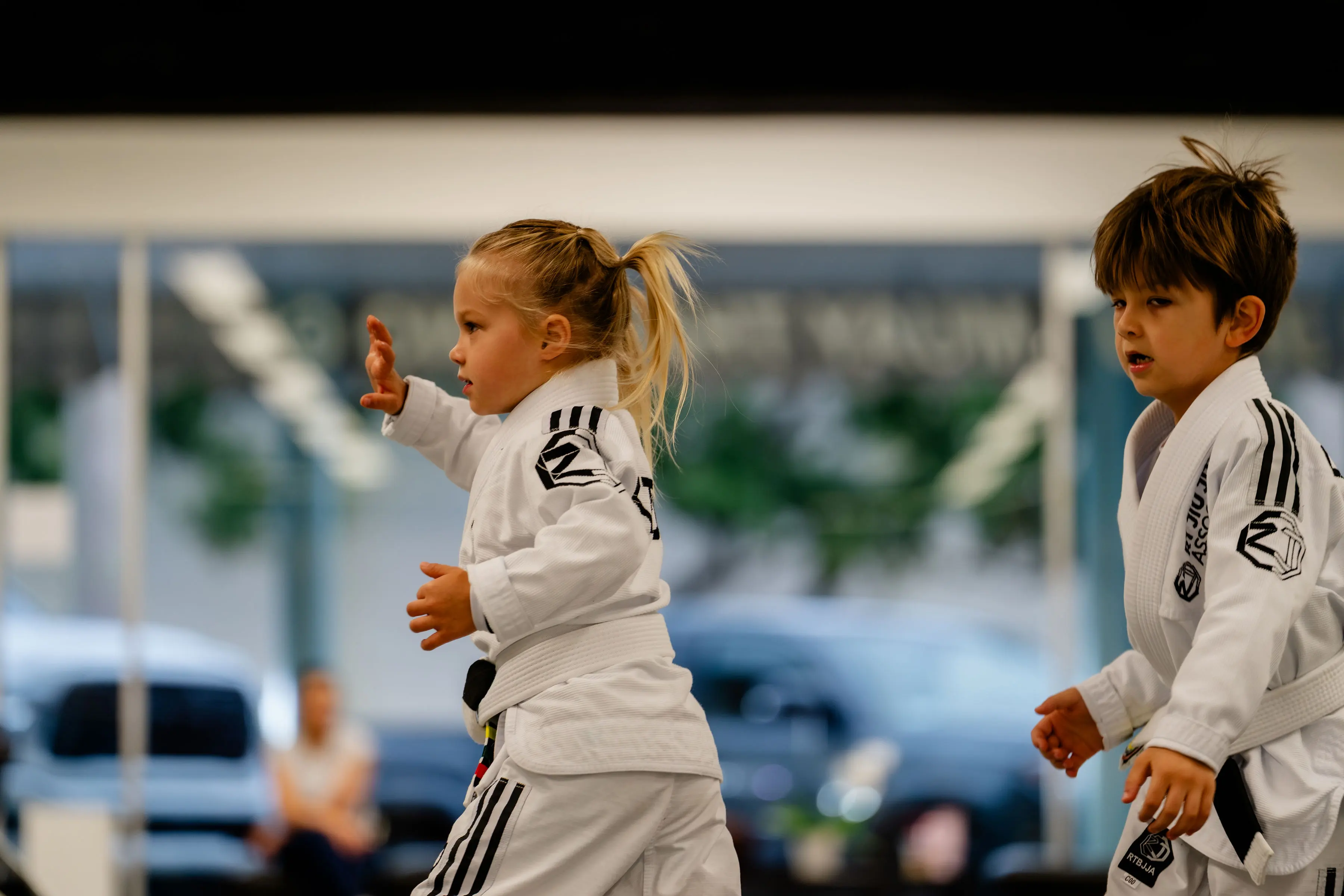 Kids Jiu Jitsu class at RT Beachside: two of the youngest students in white Gis during the warm up