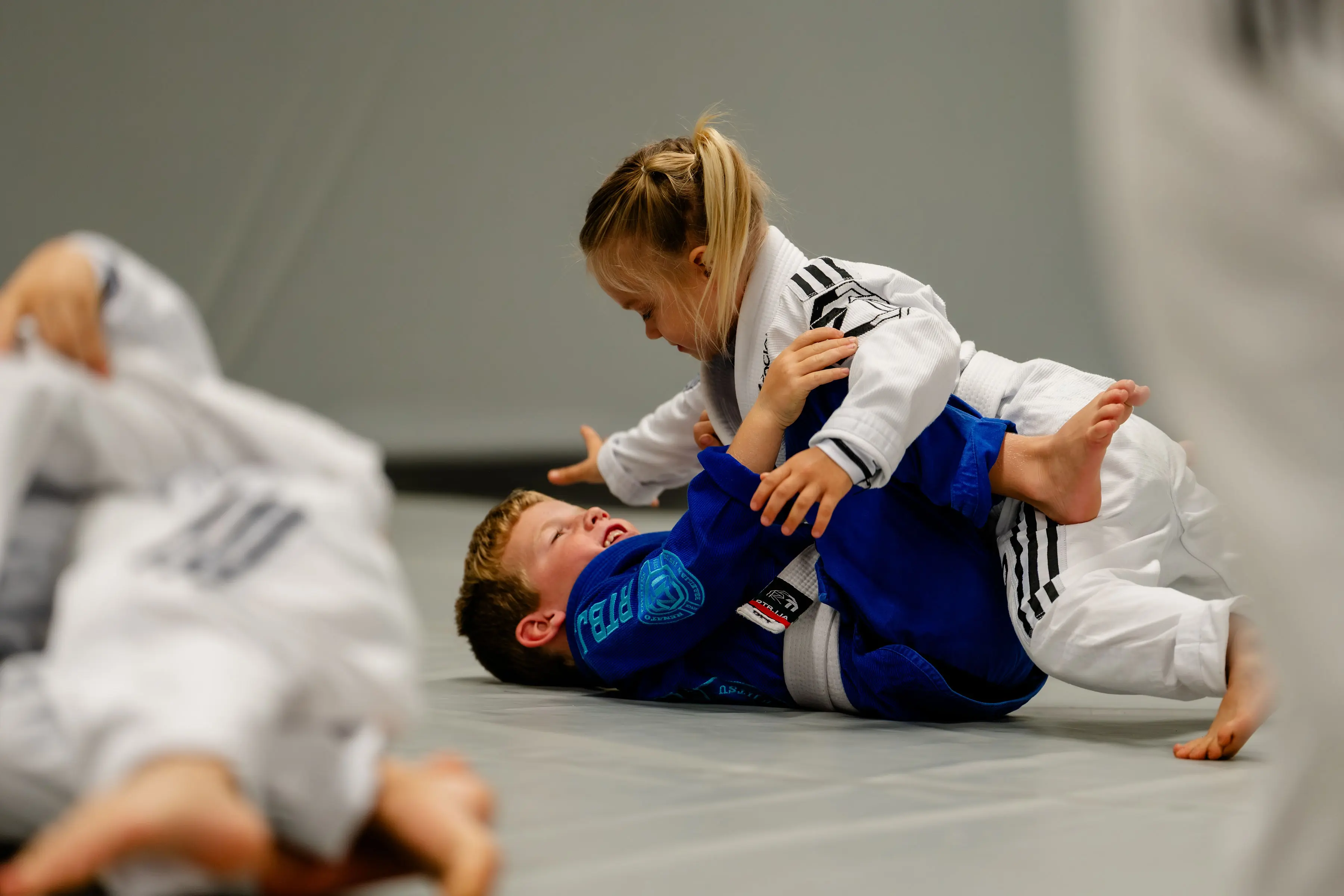 Kids Jiu Jitsu class at RT Beachside: two kids drilling on the mats, one in a white Gi and one in blue