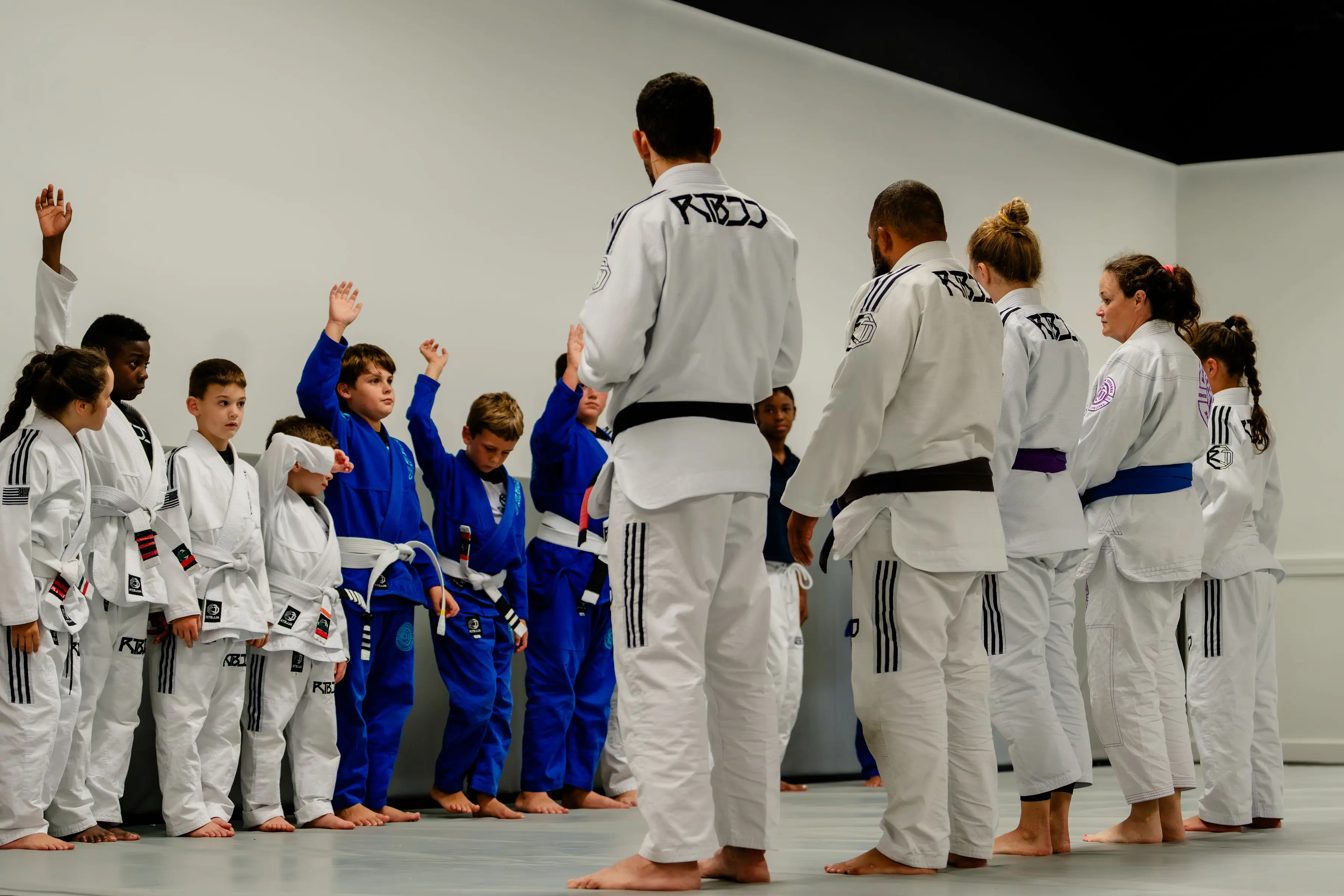 Kids Jiu Jitsu class at RT Beachside: the class with their hands up in front of the instructor